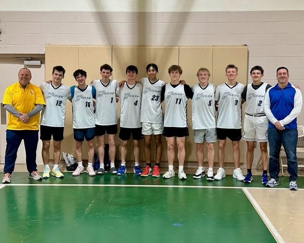 Indoor team group photo of nine athletes in white jerseys standing with two coaches on a gym court