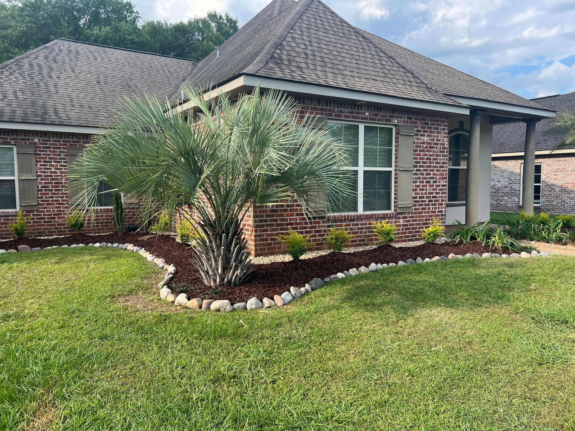 A brick house with a palm tree in front of it.