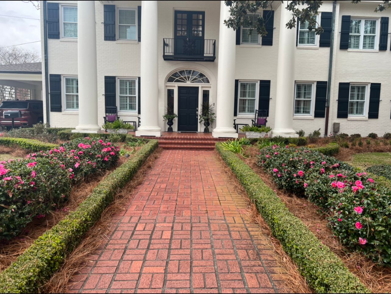 A large white house with a brick walkway leading to it