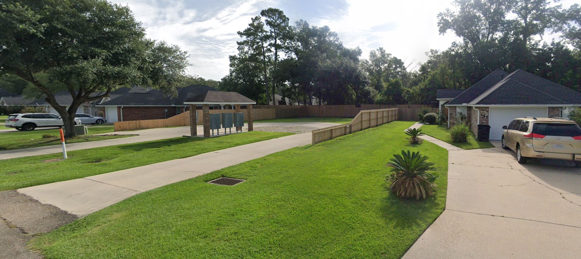 A car is parked in front of a house in a residential neighborhood.