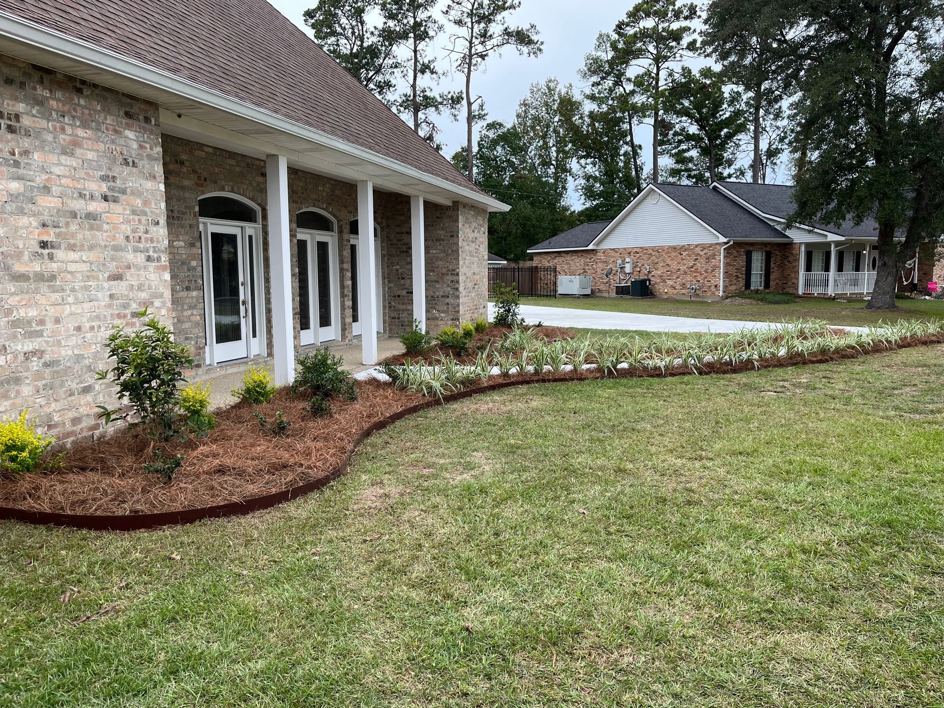 A large brick house with a lush green lawn in front of it.