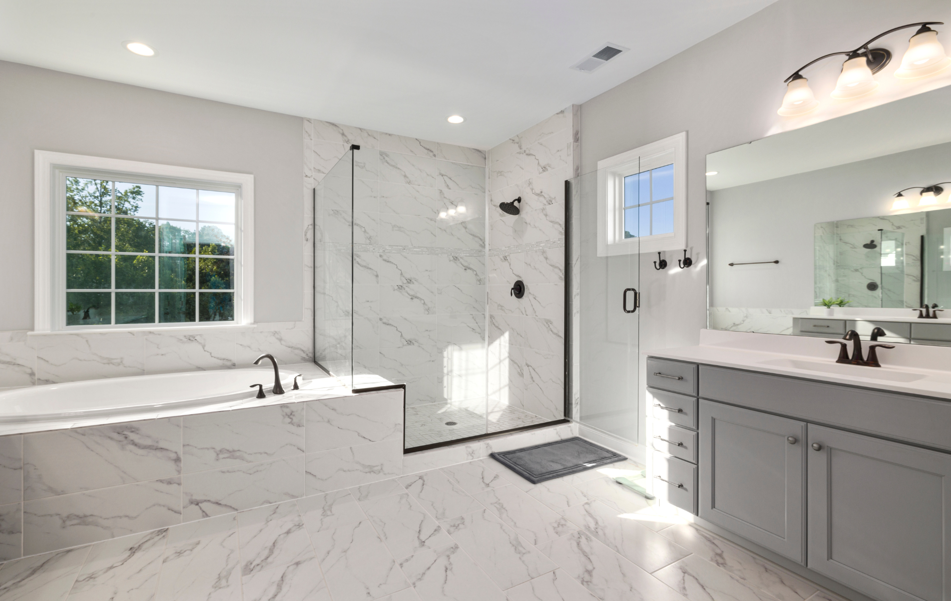 A bathroom with two sinks , a tub , and a walk in shower.