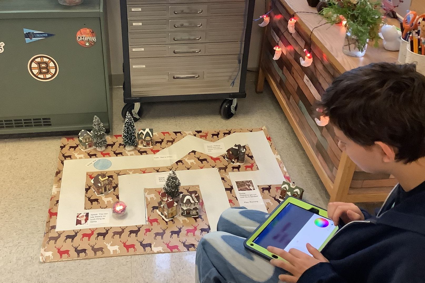 A boy is sitting on the floor using a tablet