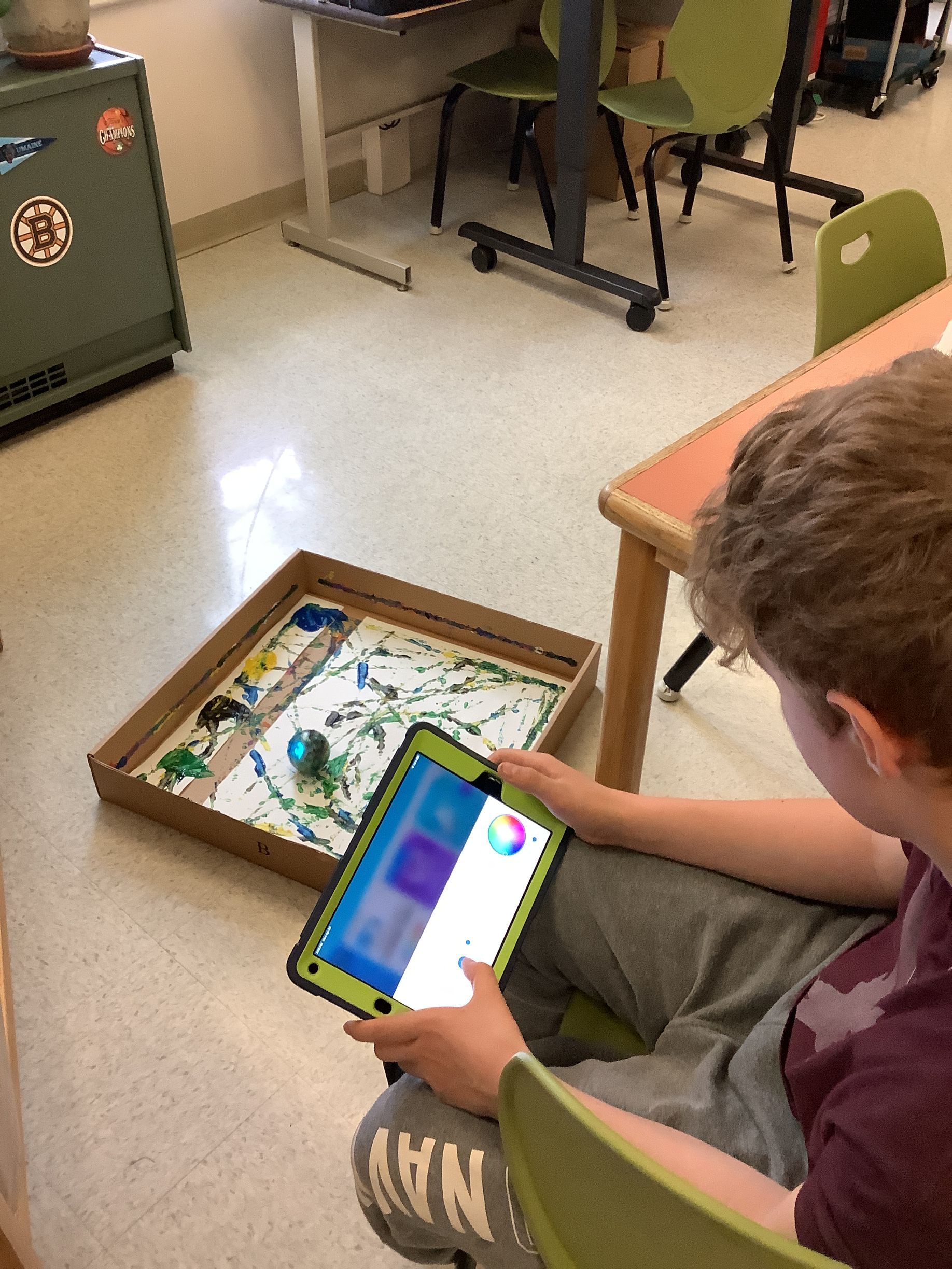 A boy is sitting on the floor using a tablet