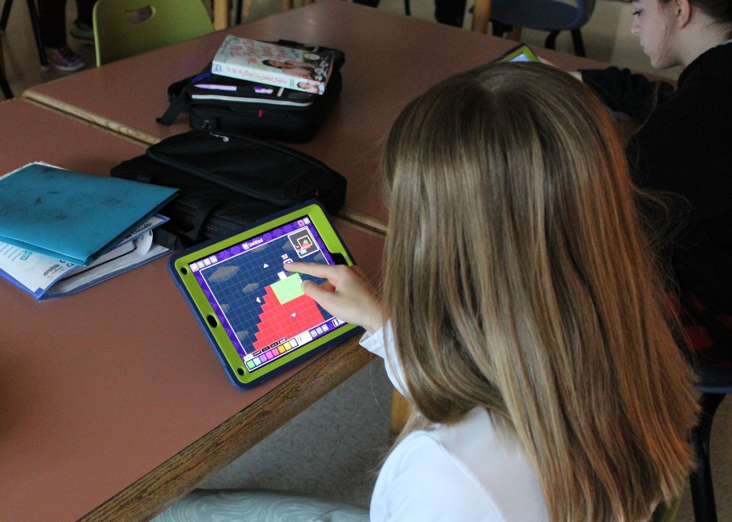 A girl is playing a game on a tablet