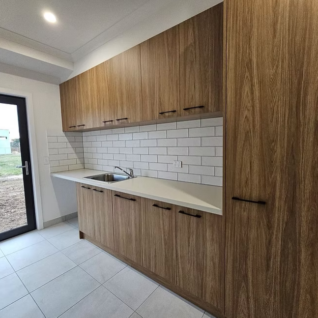 Modern kitchen with wood cabinets, white subway tile backsplash, and light tiled floor — Twomey Homes in Delacombe, VIC