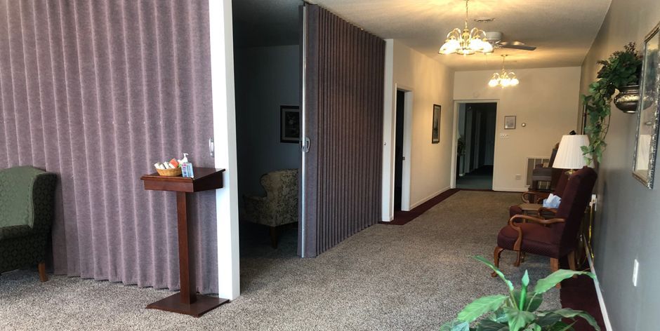 A long hallway with a table and chairs in a room.