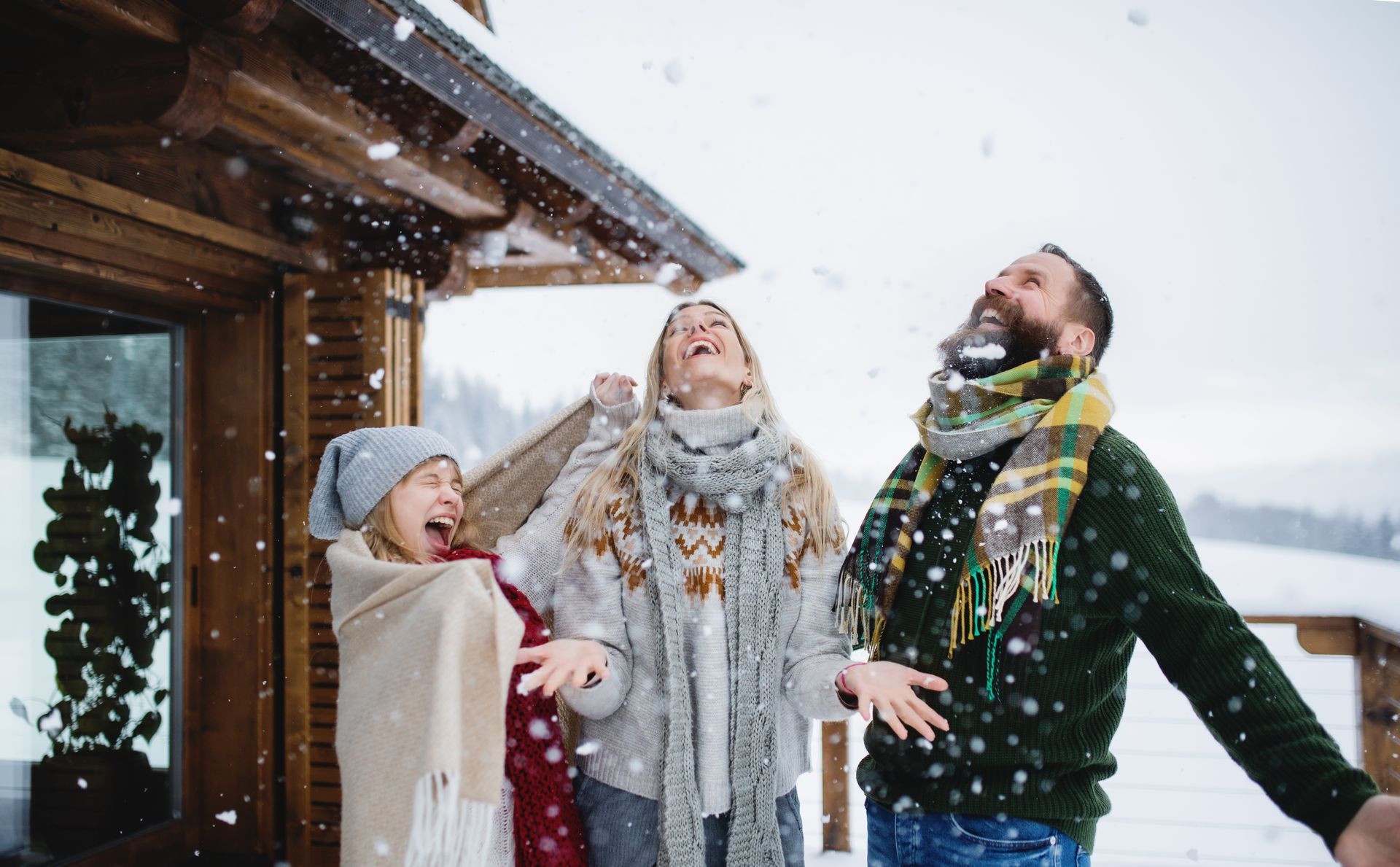 Family with a small daughter having fun on a terrace outdoors, holiday in winter nature.