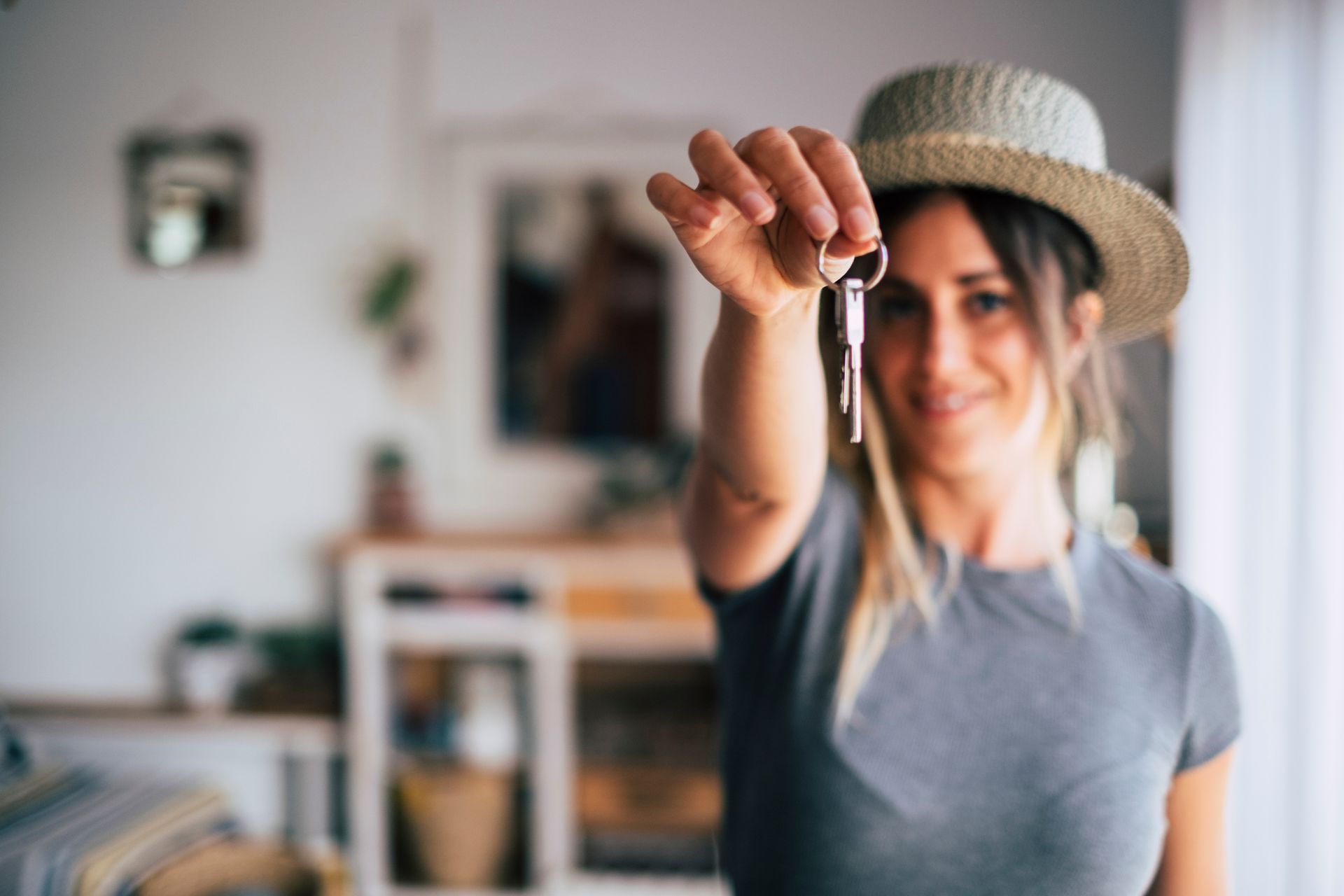 Close-up of a pair of keys being held by a young woman, smiling to the camera. Close-up of a pair of keys being held by a young woman, smiling to the camera.