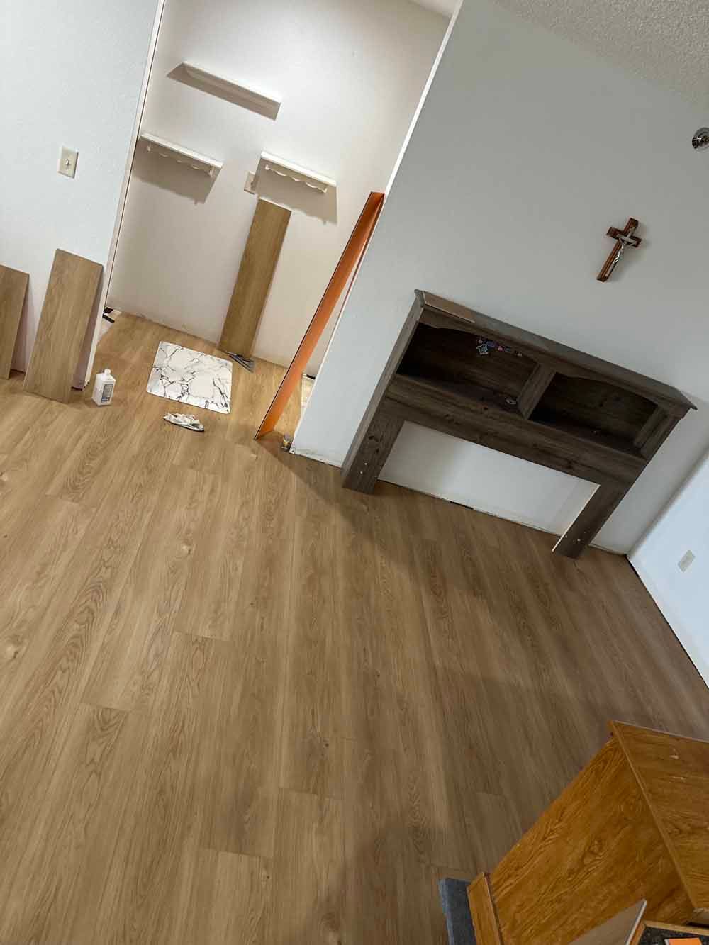 Empty room with wood floor, built-in shelves, and a recessed wall niche.