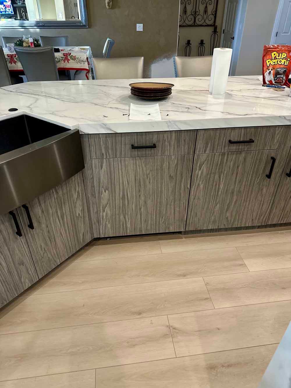 Modern kitchen with marble island, wood cabinets, and a bowl and paper towel on the counter
