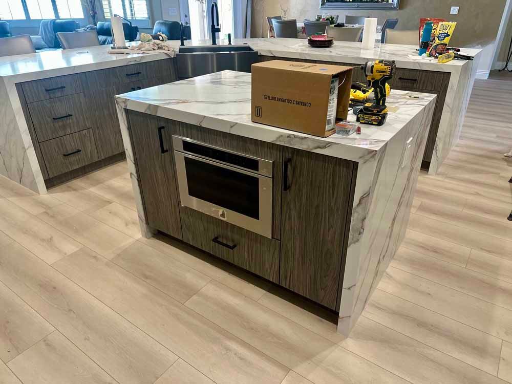 Kitchen island with marble countertop, built-in oven, and a box on top in a modern kitchen