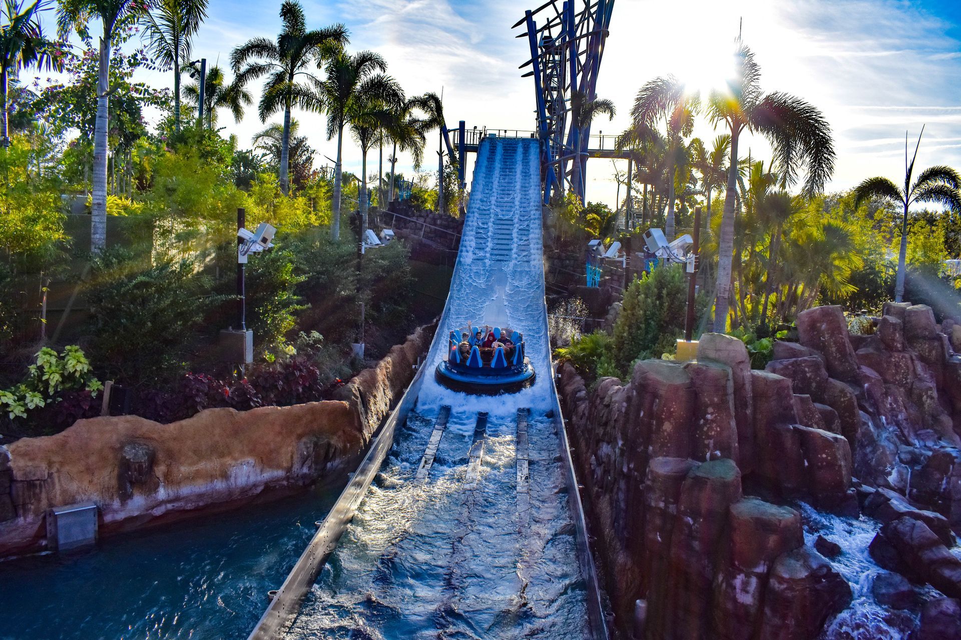 Log flume raft splashing down a steep drop in a tropical water park
