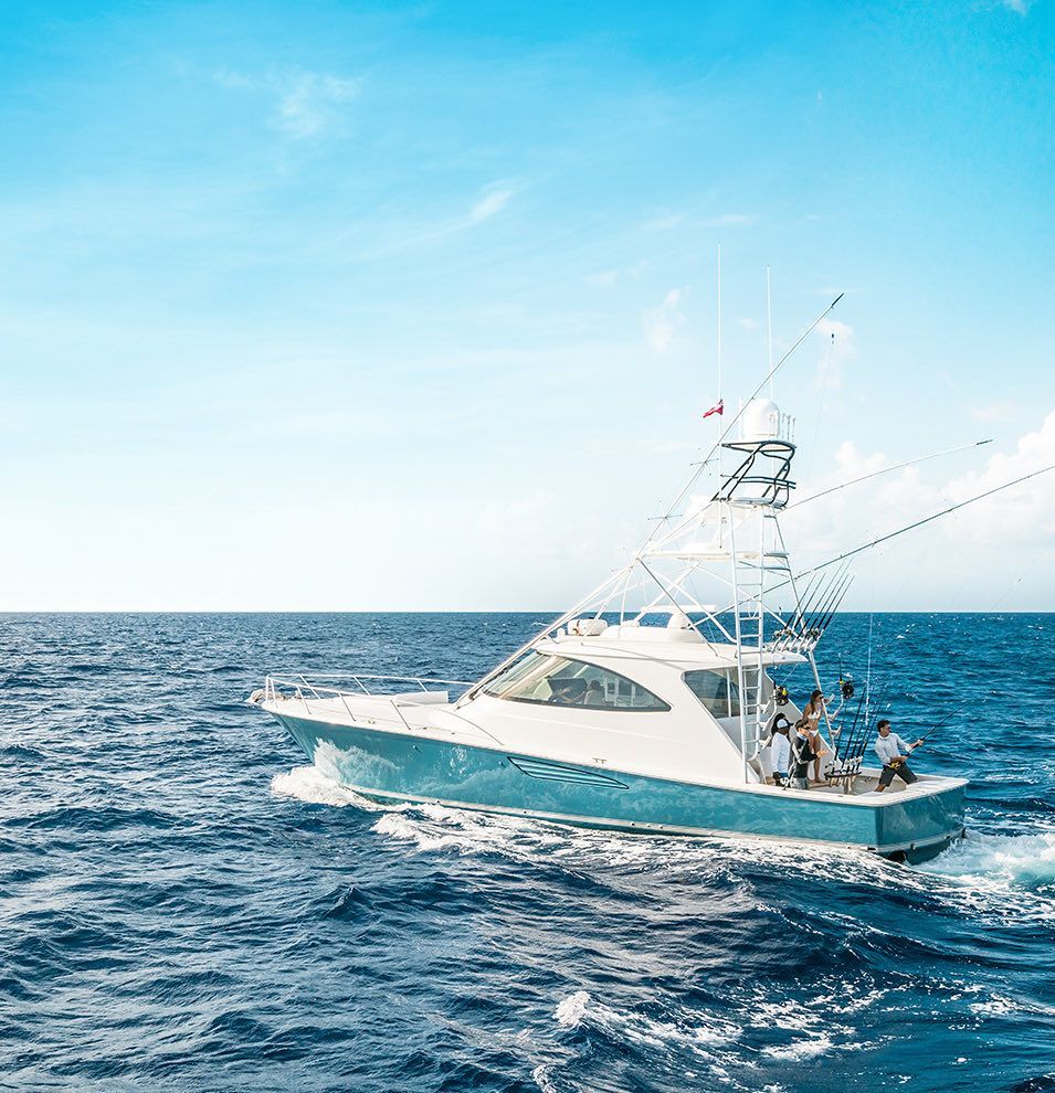 White sportfishing boat on open blue ocean under a bright sky
