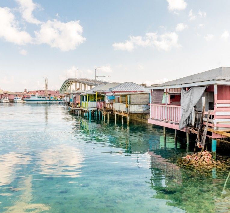 Colorful stilt houses lining clear turquoise water under a bright sky