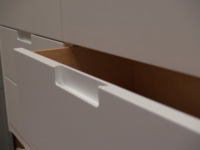 Cassetto bianco parzialmente aperto con interno marrone in un mobile