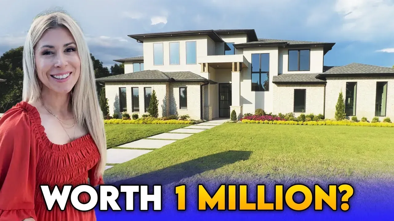 Woman in red smiles in front of a modern, beige house with large windows and a green lawn.