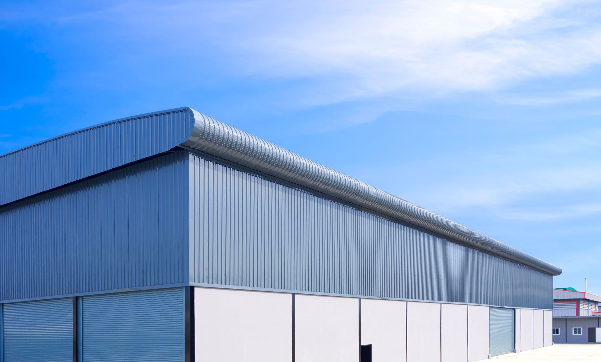 A large metal building with a blue sky in the background.