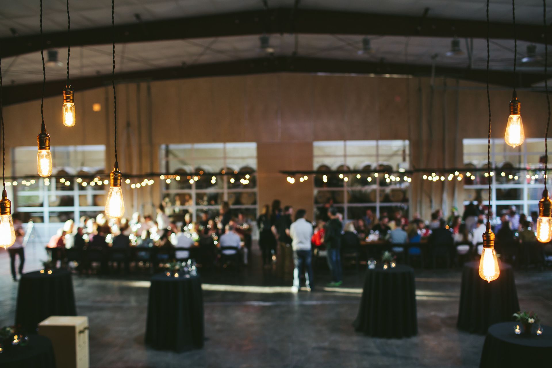 A group of people are sitting at tables in a large room.