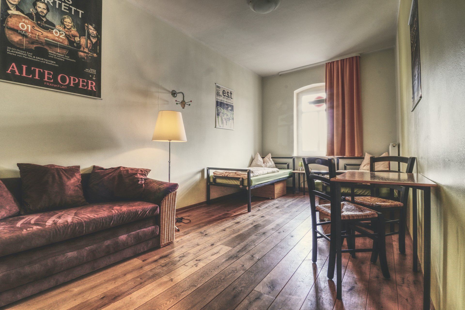 Wohnliches 2-Bettzimmer mit Sofa, Schreibtisch und Postermotiv im OPERA Hostel Erfurt