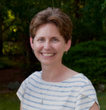 A woman in a striped shirt is smiling for the camera