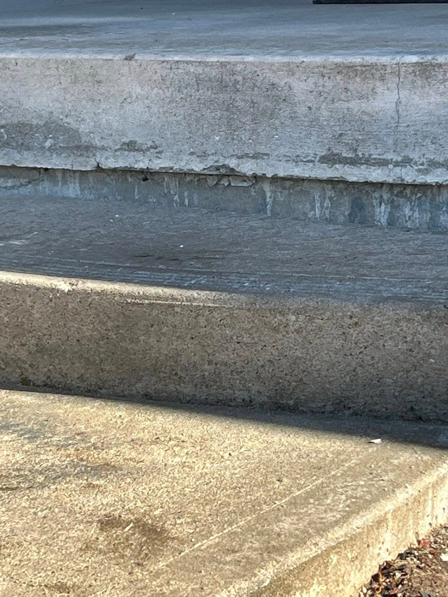 Concrete steps with gray worn edges and a sunlit landing.
