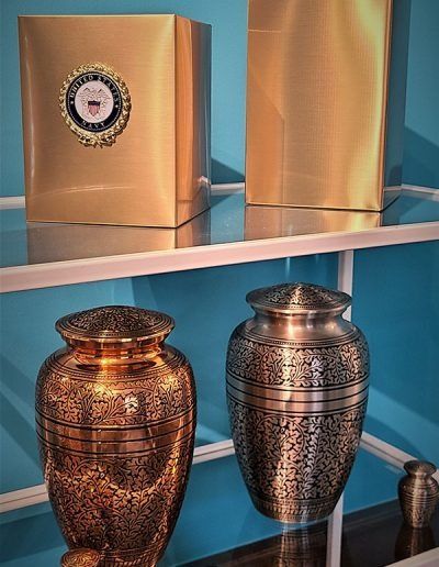 Decorative urns and gold boxes displayed on blue shelves