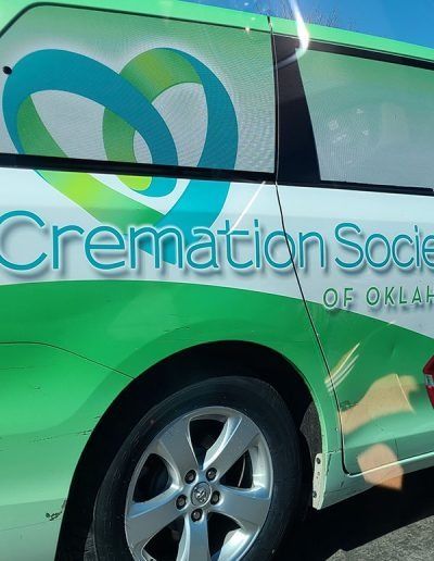 Green and white Cremation Society of Oklahoma van with heart logo and silver wheel
