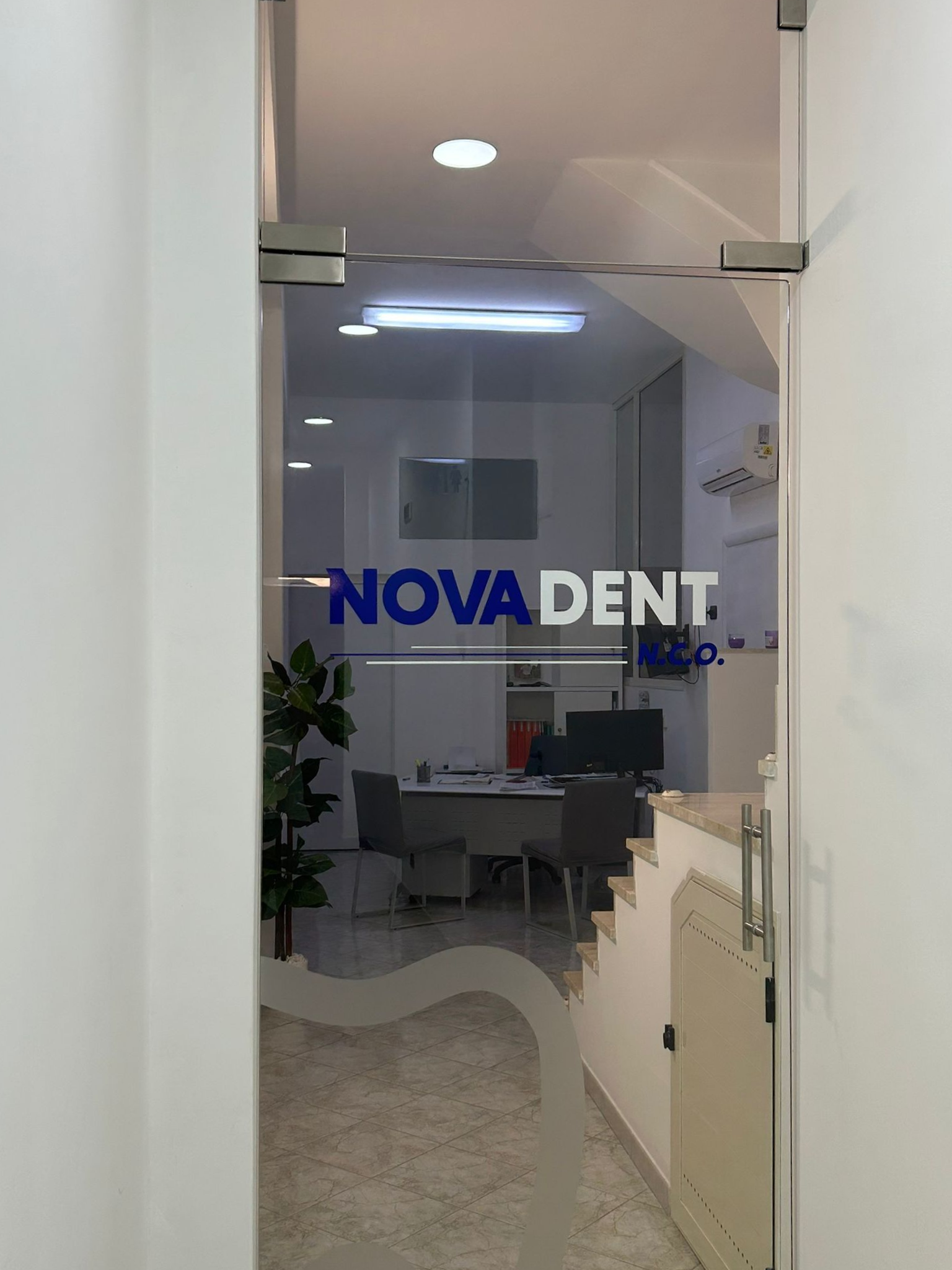 Porta d'ingresso in vetro di uno studio dentistico, logo 