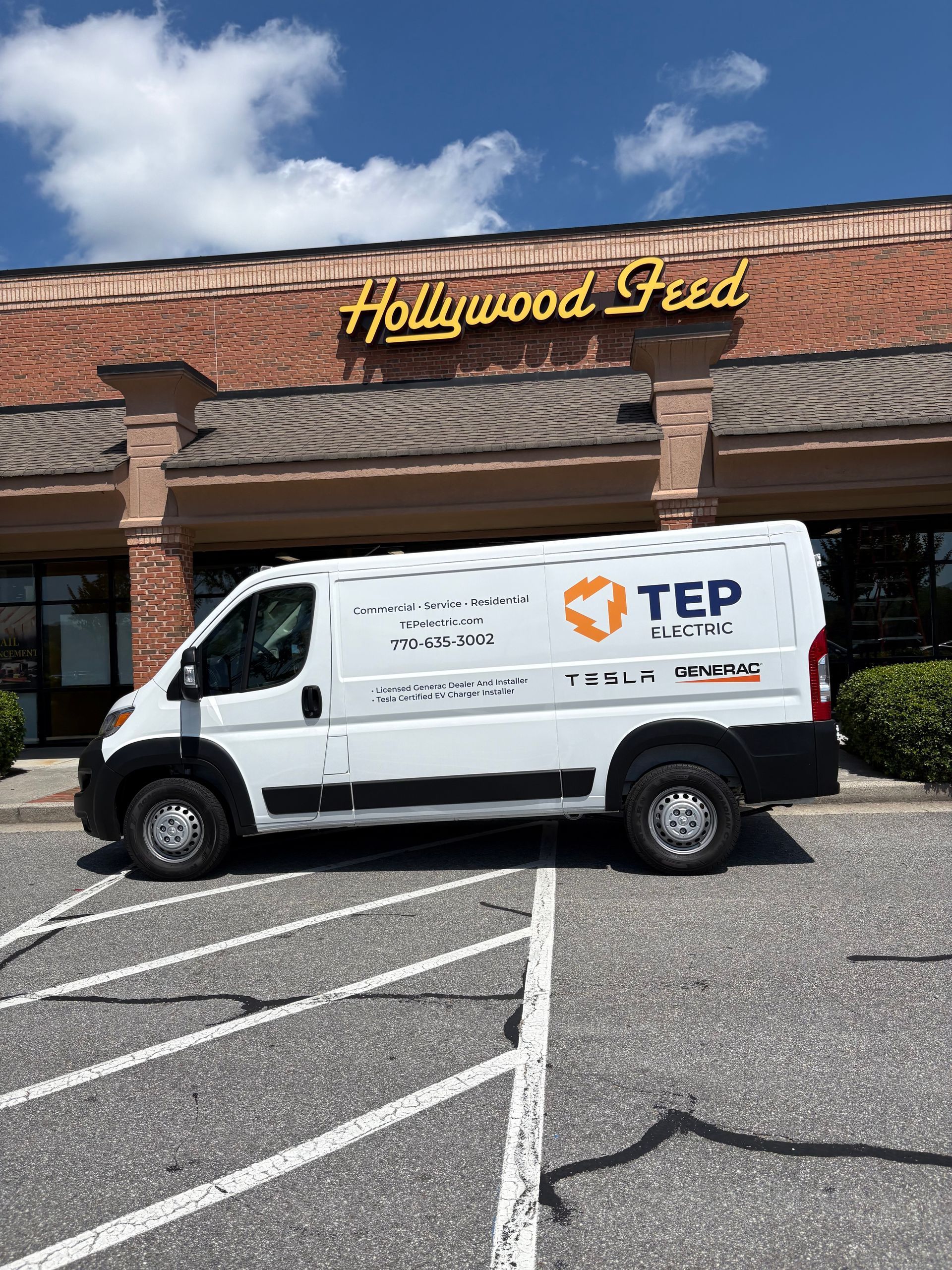 White TEP service van parked outside a Hollywood Feed store in a shopping center parking lot.