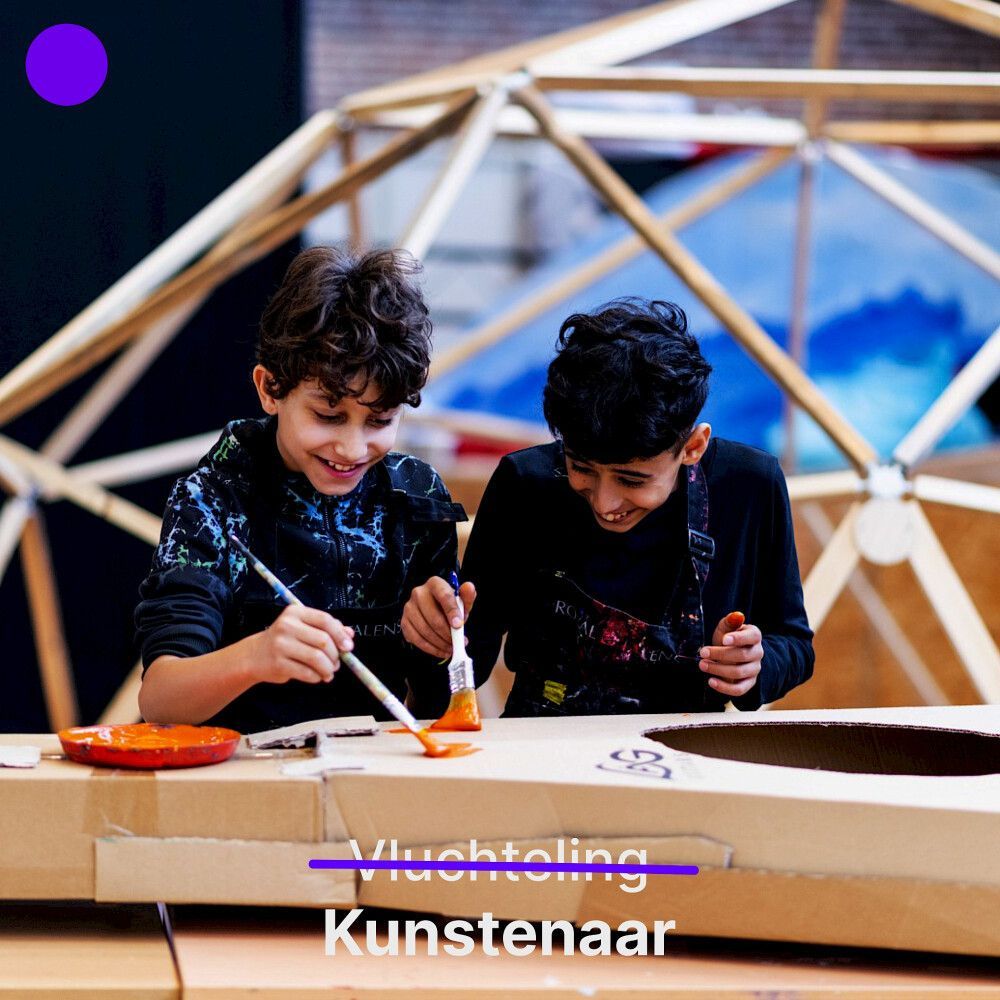 Twee jongens schilderen met een glimlach in een kunststudio, met een houten koepelconstructie op de achtergrond.