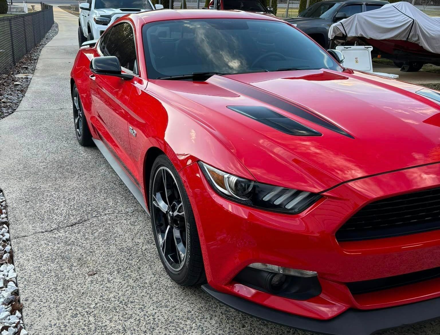 A red ford mustang is parked on the side of the road