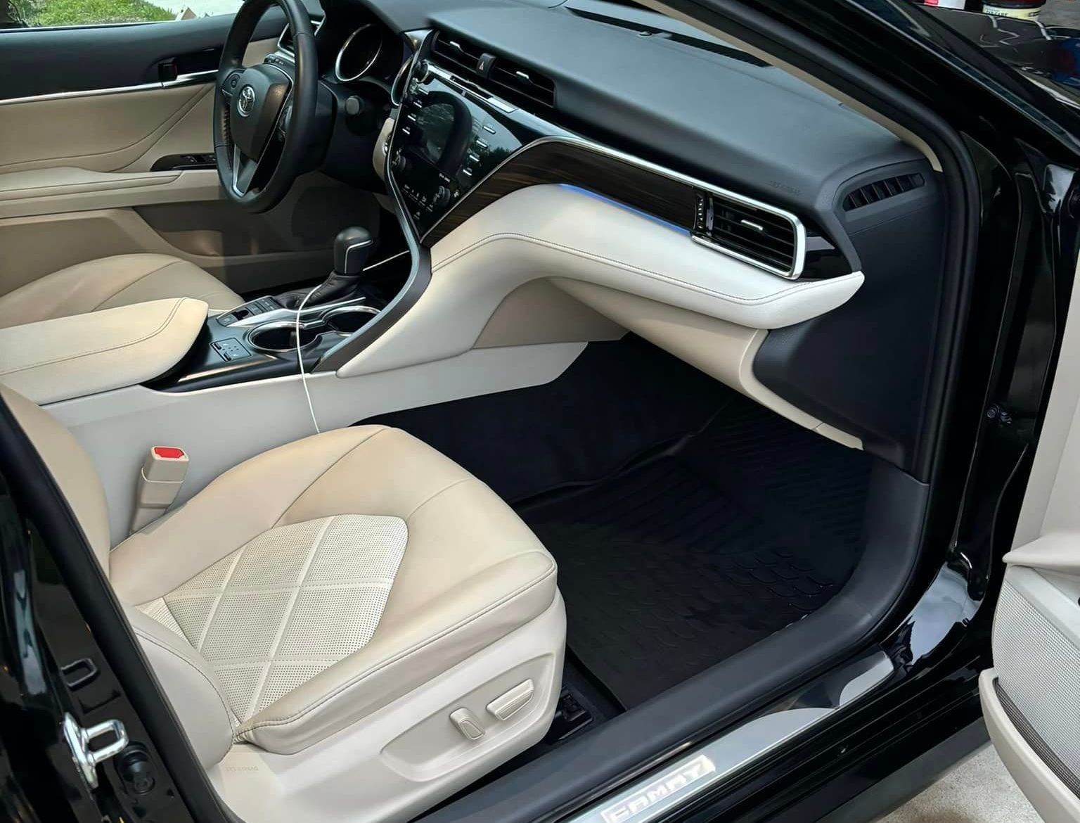 The interior of a black car with the door open