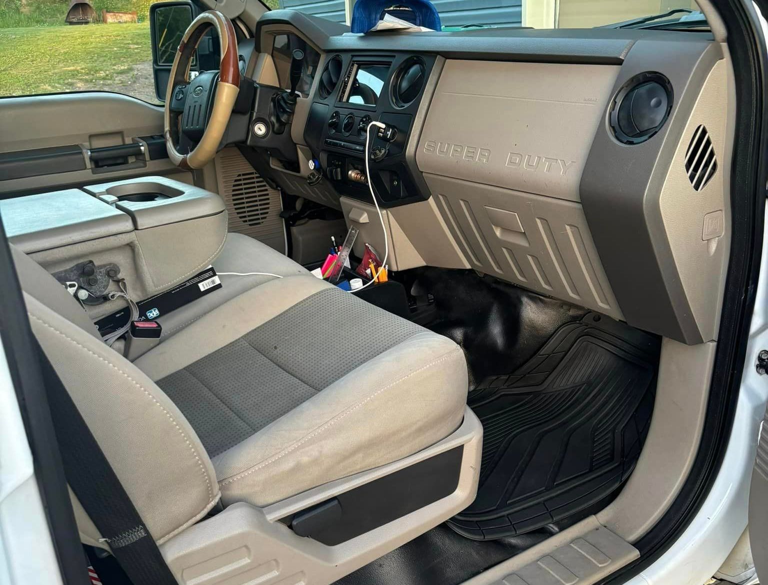 The interior of a white truck with a dog in the back seat