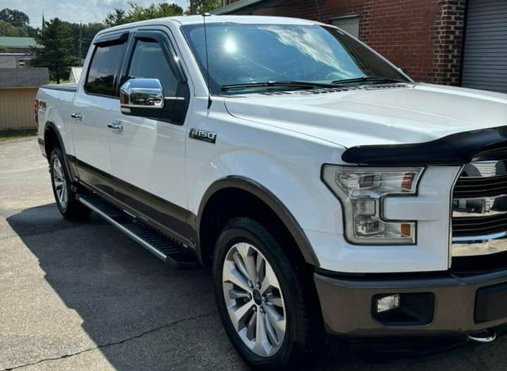 A white pickup truck is parked in front of a brick building. A white pickup truck is parked in front of a brick building.