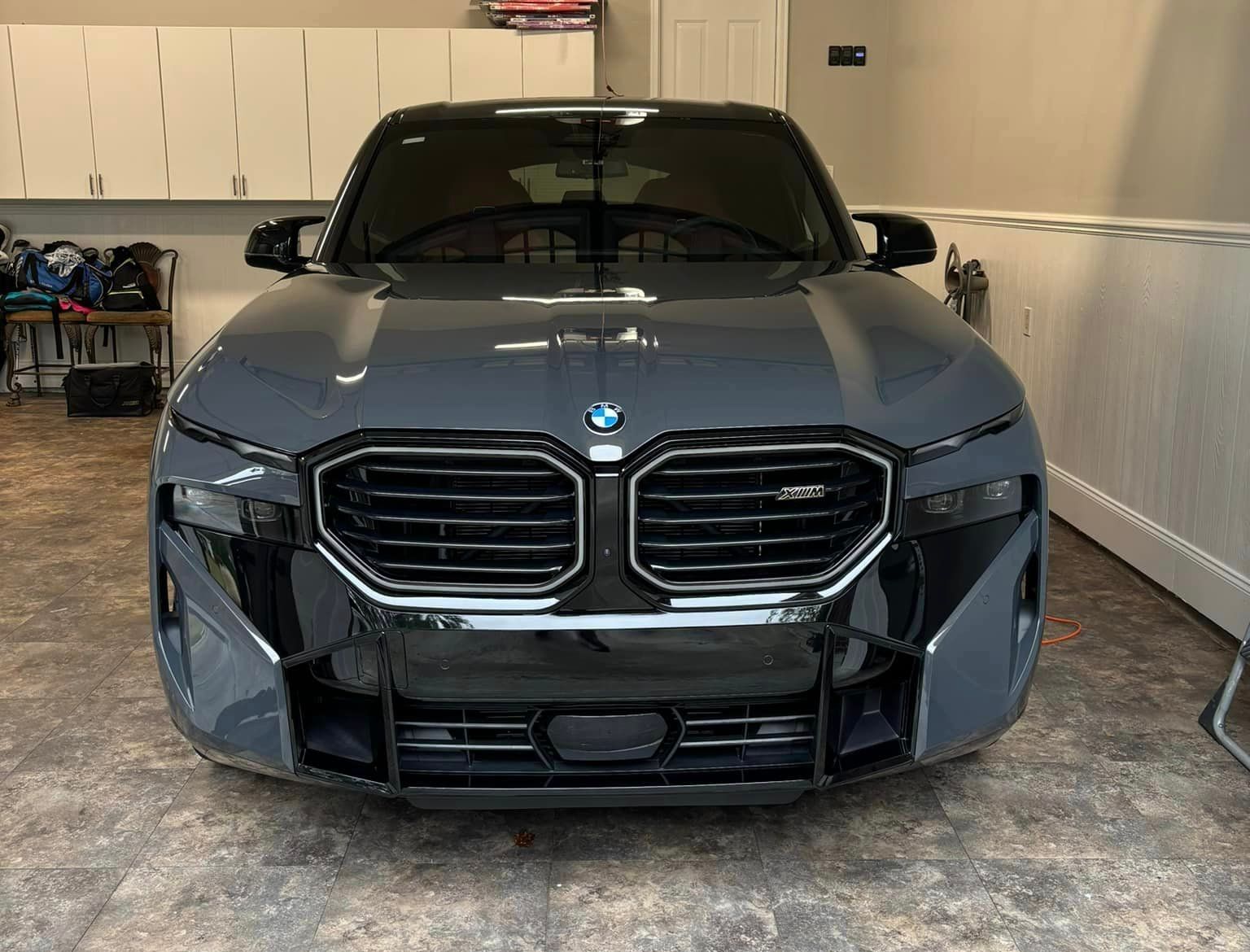 A gray bmw is parked in a garage.