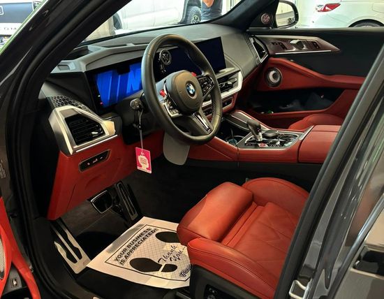 The inside of a car with red seats and a steering wheel