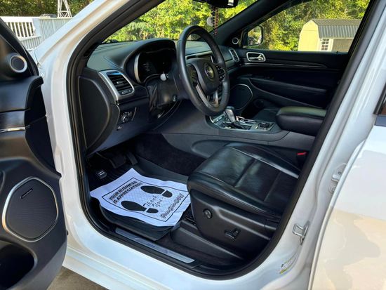 The inside of a white jeep grand cherokee with the door open.