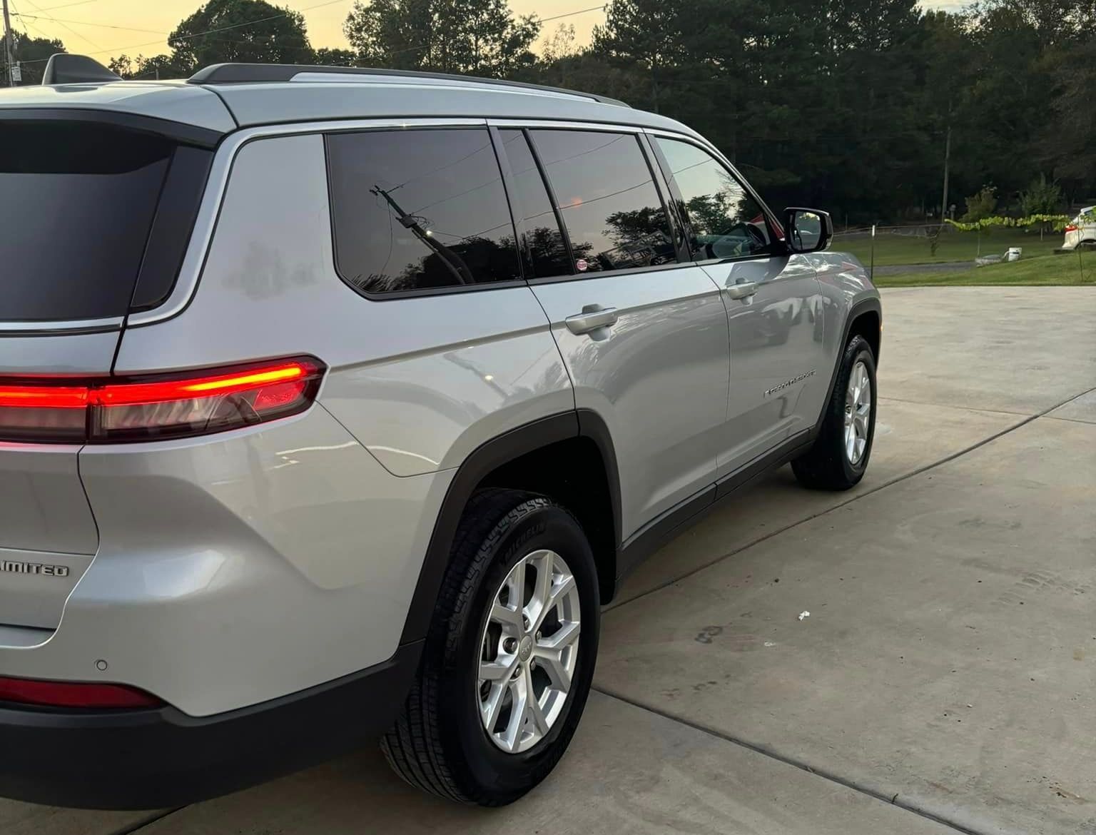 A silver jeep grand cherokee is parked in a parking lot.