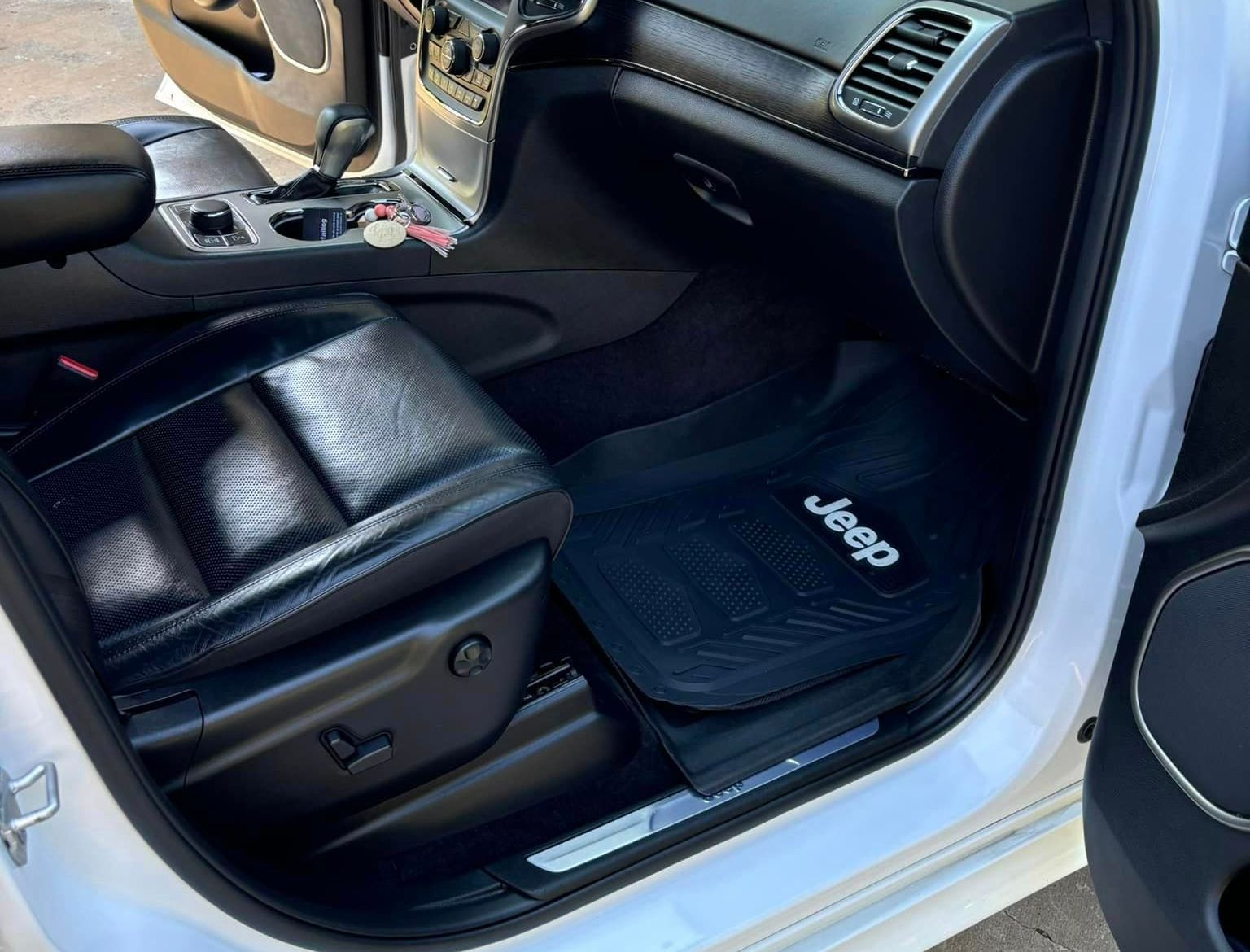 The inside of a white jeep with the door open