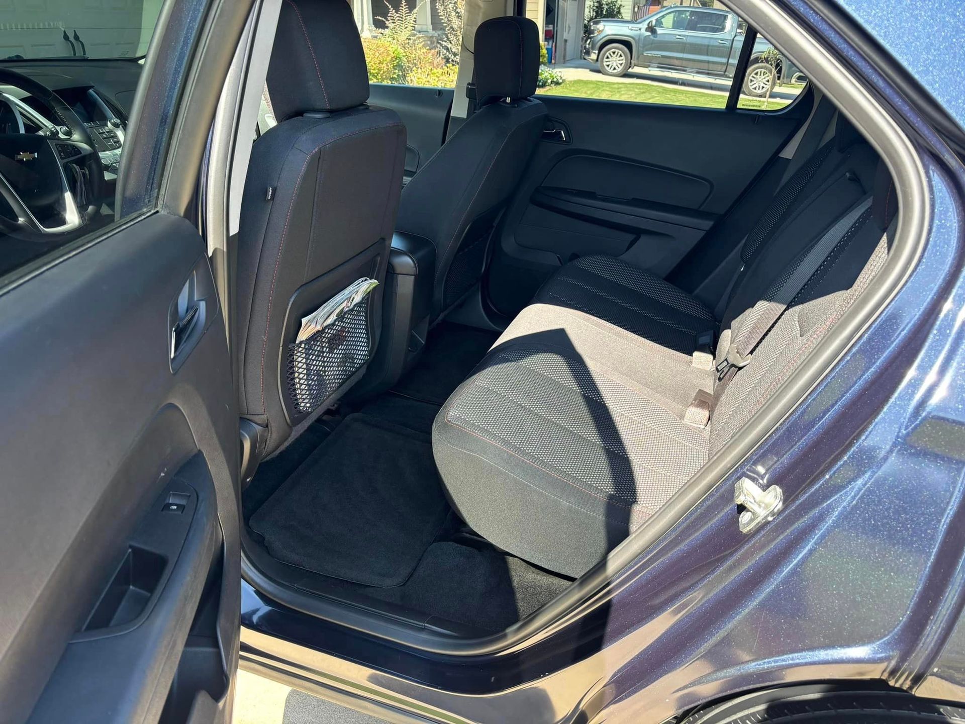 The back seat of a blue car with the door open