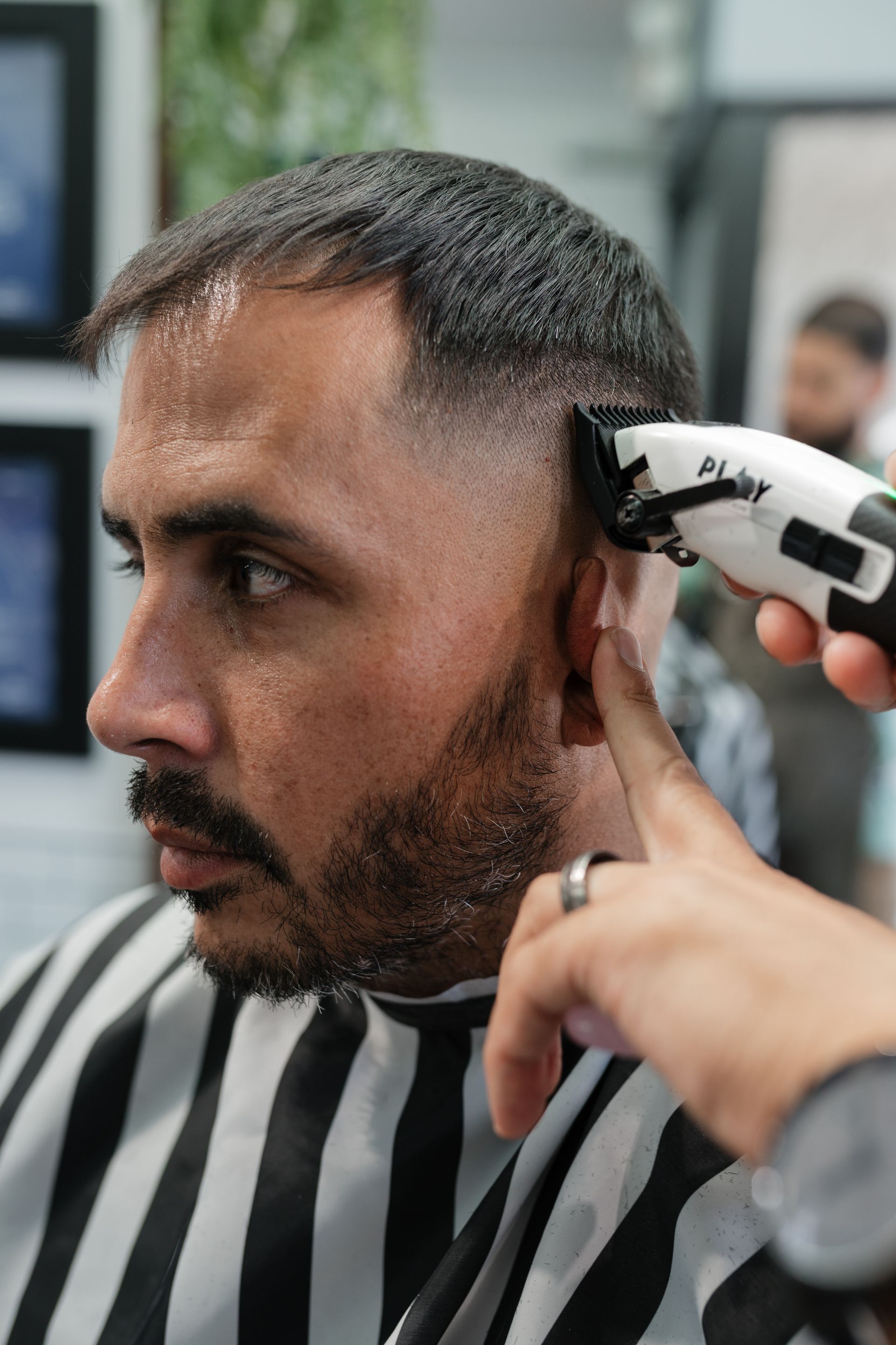 A barber detailing a fresh fade at Modern Man Barber Studio for a low-maintenance finish.