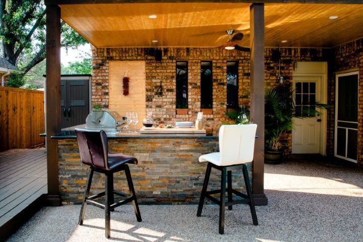 Backyard outdoor bar area with a white and a black stool chair. 