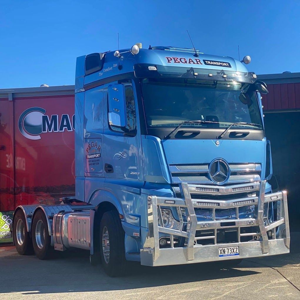 A Delivery Man Is Writing On A Clipboard In Front Of A Truck — Pegar Transport In Sydney, NSW