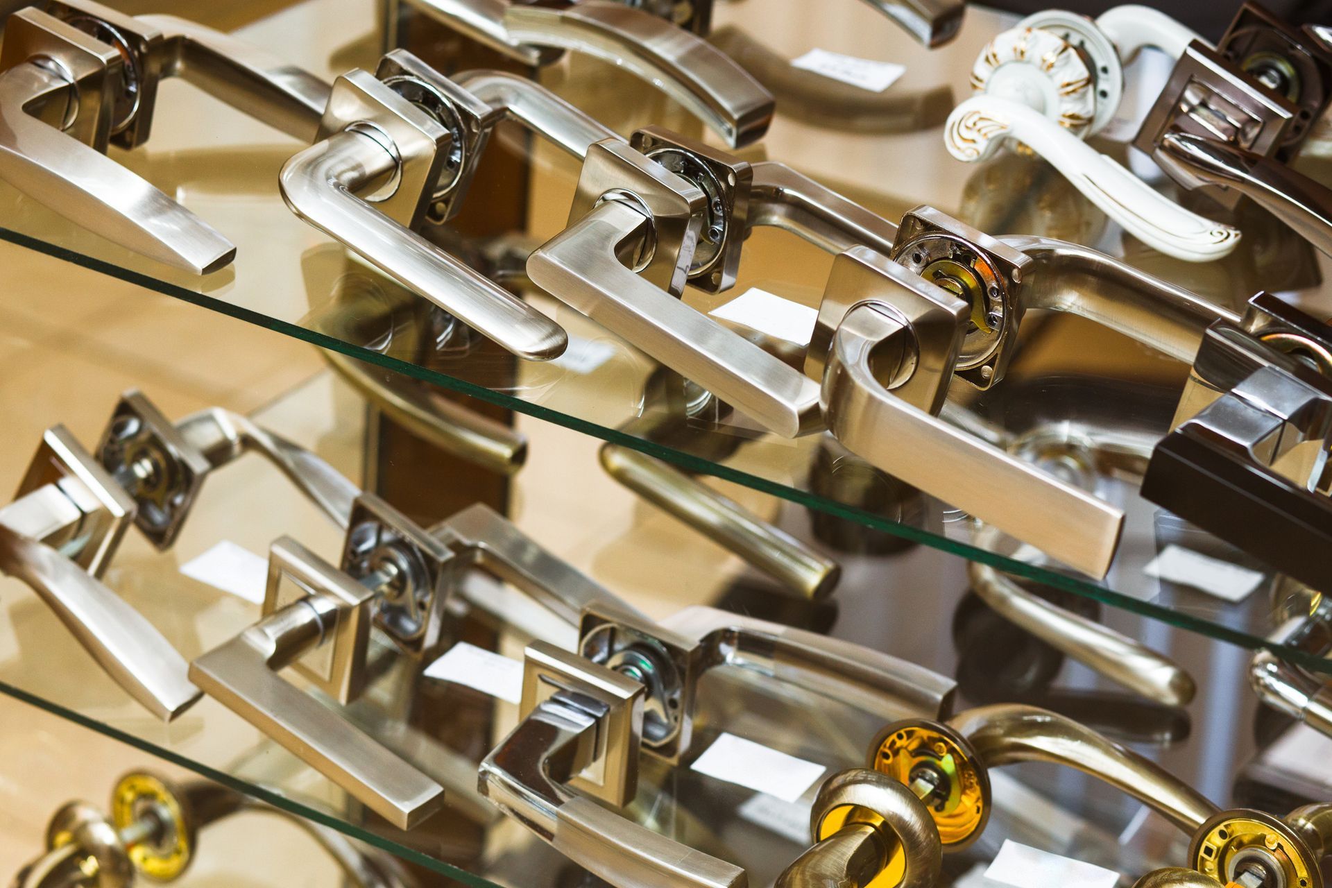 Door closers in a specialized store. Door handles displayed on glass shelves.