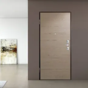 una porta di legno e accanto due sedie rosse e una mensola con due vasi in vetro