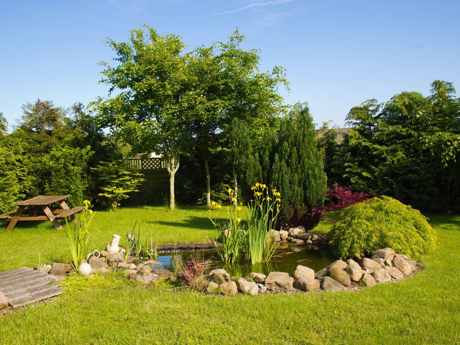A Garden with a Pond surrounded by Rocks and Trees - Tulsa, OK - Outdoor Orchestrators