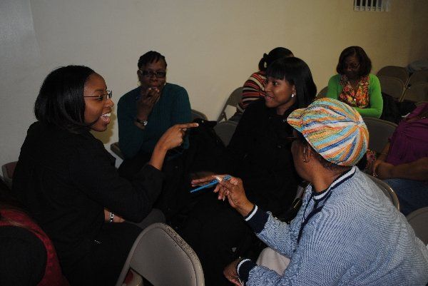 A group of women are sitting in a circle talking to each other