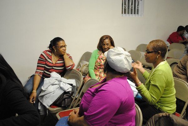 A group of women are sitting in chairs talking to each other
