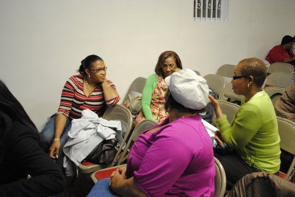 A group of women are sitting in chairs talking to each other
